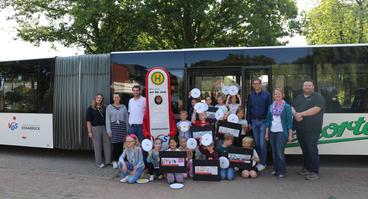 Zum Start der Schulanfängeraktion besuchte das VOS-Team gemeinsam mit dem Busunternehmen Nieporte die Grundschule Ankum – mit dabei: die Erstklässler und Erstklässlerinnen, Schulleiter und Lehrkräfte sowie das Maskottchen Haltelinchen.