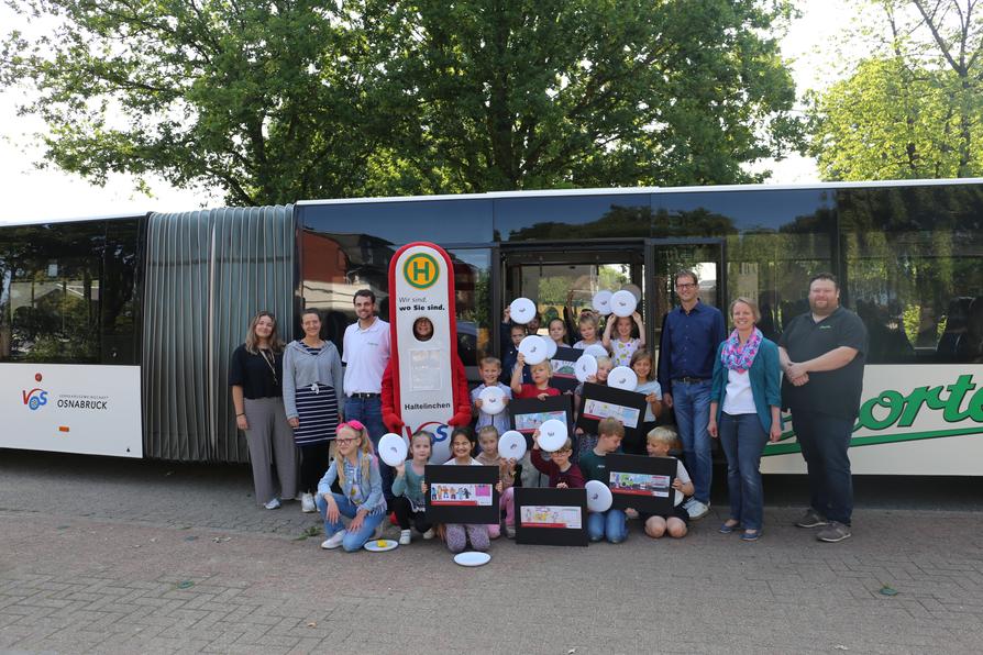 Zum Start der Schulanfängeraktion besuchte das VOS-Team gemeinsam mit dem Busunternehmen Nieporte die Grundschule Ankum – mit dabei: die Erstklässler und Erstklässlerinnen, Schulleiter und Lehrkräfte sowie das Maskottchen Haltelinchen.