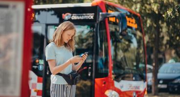 Kundin wartet auf den Bus der VOS