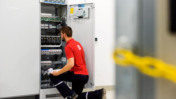 Ein Mitarbeiter der SWO Netz GmbH sitzt vor einem Stromschaltkasten