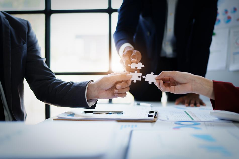 Geschäftsleute mit Puzzleteilen im Büro