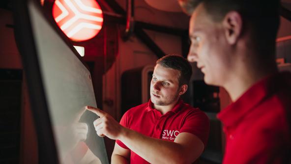 Mitarbeiter der SWO Netz stehen vor einem Bildschirm