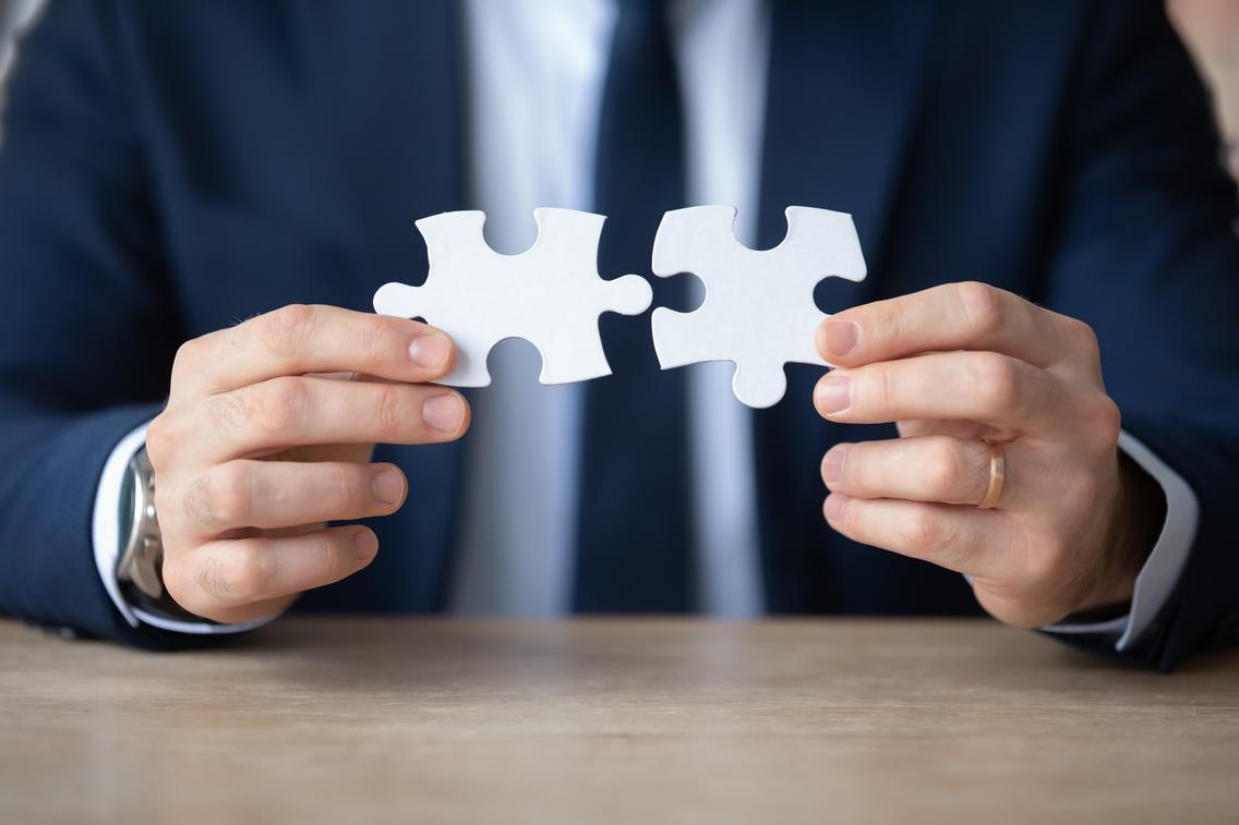 Geschäftsperson hält zwei Puzzleteile 